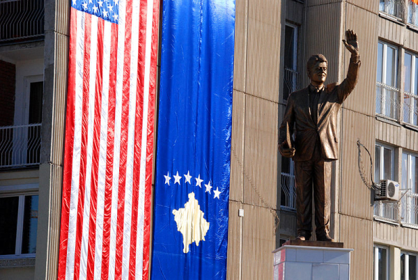 Estátua de Bill Cliton e bandeiras de EUA e Kosovo em Pristina